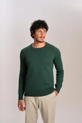 Sweater de punto fino color verde oscuro, con cuello redondo y mangas largas con puños acanalados. Presenta un pequeño logo bordado en el pecho.