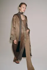 Kimono de la colección ZW de Zara, confeccionado en tejido marrón con acabado satinado. Presenta solapas anchas en tono verde con estampado estilo jacquard y flecos largos colgantes en el frente. Cuenta con mangas largas con puños estampados y bolsillos laterales ocultos.