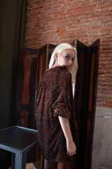 Camisa de corte recto y estructura clásica, confeccionada en tela de encaje con detalles de terciopelo en color verde esmeralda. Presenta cuello camisero, cierre frontal con botones y mangas largas con puños abotonados.