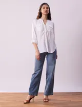 Blusa color beige de lino, marca Dash. Cuello a la base, escote en V y abertura con botones. Delantera con bolsillos. Largo de manga regulable con presilla y botón.