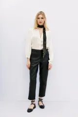 Pantalon de corte recto confeccionado en cuero ovino con acabado metalizado en color plata. Presenta cierre frontal con cremallera y bolsillos laterales.