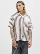 Camisa resort de manga corta color beige, con patrón geométrico de rayas verticales en tonos bordó, cuello camisero, cierre frontal de botones y calce relajado.