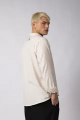 Camisa de manga larga con cuello clásico y cierre frontal de botones. Presenta un calce relajado y una textura liviana.