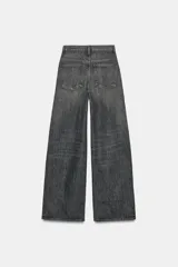 Jeans de tiro alto con diseño de pierna ancha y corte extra largo. Presenta una cintura cruzada asimétrica con cierre de cremallera y botones metálicos, además de un diseño clásico de cinco bolsillos.