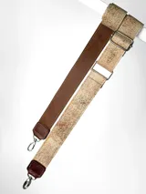 Correa ajustable para cartera confeccionada en cuero, con diseño pintado a mano en tono beige con textura moteada y reverso en cuero liso color marrón. Incluye herrajes metálicos plateados.