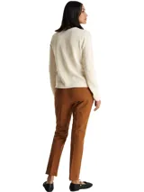 Sweater de lana de corte regular con cuello redondo y mangas largas. Presenta un diseño minimalista en color beige con el logo de la marca bordado en el pecho.