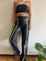 Pantalón de cuero negro con textura de piel de cocodrilo y rayas blancas laterales.