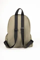 Mochila de diseño funcional en color verde militar, confeccionada en material sintético resistente. Cuenta con un compartimento principal con cierre, dos bolsillos frontales con cierres metálicos visibles, y bolsillos laterales. Incluye asas traseras regulables y una manija superior fija. Presenta un parche con el logo de la marca en la parte frontal.