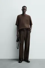 Remera de corte relajado confeccionada en tejido compacto de mezcla de algodón con elasticidad. Presenta cuello redondo, manga corta y un bolsillo frontal de plastrón.