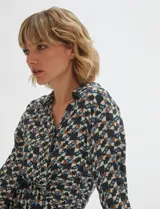 Camisa de manga larga con estampado geométrico en tonos verde inglés, marrón y celeste, cuello camisero y cierre frontal de botones.