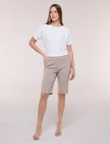 Bermuda elastizada de tiro alto estilo marinero, color beige, con detalle de botones metálicos decorativos en los laterales y aberturas en el ruedo.