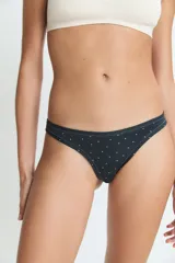 Bombacha tipo colaless de color negro con estampado de pequeños puntos blancos, confeccionada en poliamida y elastano con forro de algodón.