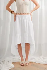 Falda midi blanca de lino, con cintura elastizada y ruedo irregular con volantes.
