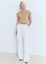 Jersey de punto fino color beige, con cuello redondo y manga corta. Presenta un diseño recto y minimalista.