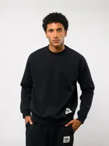 Buzo de felpa negro con cuello redondo, manga larga y etiqueta con el logo de Umbro en la parte delantera inferior.