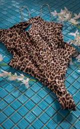 Traje de baño enterizo blanco con breteles finos y abertura en el pecho.