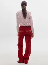 Pantalón de tiro medio confeccionado en pana color rojo, con corte holgado y detalle de línea lateral en contraste.