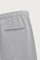 Pantalón jogger de corte regular fit y color negro, confeccionado en tejido compacto de algodón con interior de rizo. Cuenta con cintura elástica, bolsillos frontales y un bolsillo trasero de doble vivo.