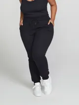 Pantalón babucha de algodón color negro, con cintura elástica con cordón ajustable y puños en los tobillos.