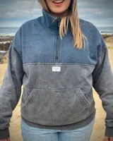 Buzo oversize de color gris oscuro con efecto stone wash, cuello alto con medio cierre y bolsillo frontal tipo canguro.