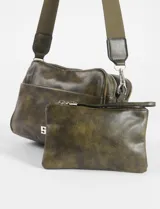 Bandolera pequeña de cuero sintético marrón con efecto desgastado, con doble cierre y estuche removible. Tiene una correa de tela ajustable en color beige.