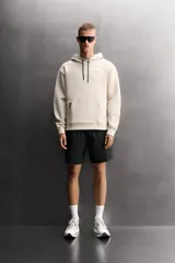 Sudadera de hombre Zara Athleticz de ajuste relajado (relaxed fit), color marrón, confeccionada en tejido técnico compacto con mezcla de algodón y elasticidad. Cuenta con cuello con capucha ajustable con cordones negros, manga larga, bolsillo frontal tipo canguro con un pequeño bolsillo termofijado con cierre, y acabados con rib en puños y cintura.