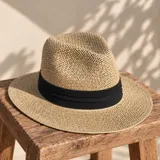Sombrero de paja estilo fedora con cinta negra ancha alrededor de la copa.