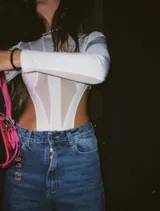 Body blanco de mangas largas con transparencias y recortes geométricos.