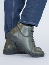 Botín de cuero color verde militar con cordones negros y suela de poliuretano.