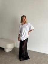 Pollera larga de encaje negro, corte recto y tiro alto.