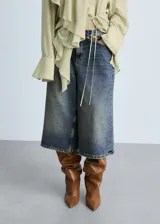 Short de jean estilo wideleg con diseño midi, tiro bajo y cinco bolsillos. Confeccionado en tejido de algodón con efecto desgastado.