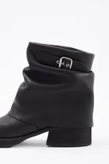 Botin de cuero vacuno color marrón con diseño de caña arrugada, punta redondeada y suela de plataforma negra con taco cuadrado.