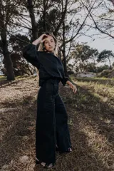 Pantalón palazzo color crudo con detalle de cinta bordada en los laterales y lazo en la cintura.