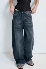 Jeans de tiro medio con corte baggy y bajo acabado en vuelta. Cuenta con trabillas, cinco bolsillos y cierre frontal con cremallera y botón metálico.