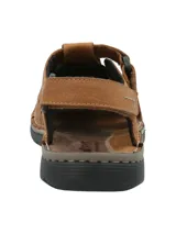 Sandalia de cuero color marrón con diseño de tiras entrelazadas y perforaciones decorativas. Cuenta con ajuste de velcro en el tobillo y suela de poliuretano negra con costuras visibles.