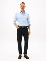 Camisa de algodón elástico con tejido dobby, color celeste claro, de corte slim, cuello con botones y puños redondeados con botón. Presenta el logo de Tommy Hilfiger bordado en el pecho.