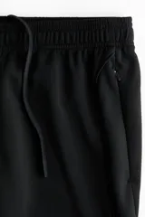 Pantalón deportivo de fútbol en color negro con tecnología DryMove, de corte ajustado, con cintura elástica con cordón ajustable, bolsillos laterales con cierre y cierres en los tobillos.