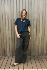 Remera oversize azul marino de tela con brillo y cuello redondo.