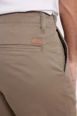 Pantalón chino de hombre color verde oscuro, corte slim, confeccionado en algodón con elastano, con triple pespunte en las costuras y botones al tono.