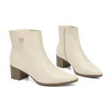 Bota corta de cuero negro con taco cuadrado y punta fina. Presenta un detalle metálico dorado con logo en el lateral superior y cierre lateral.