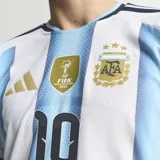 Camiseta de fútbol Adidas de la Selección Argentina, versión jugador, con el número 10 estampado. Presenta el diseño clásico de franjas verticales celestes y blancas, con detalles en negro en los hombros y cuello. Incluye el escudo de la AFA con tres estrellas y el parche de campeón mundial FIFA.
