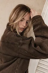 Campera de jean en color marrón chocolate con efecto lavado, corte semi oversized, cierre frontal metálico, cuello clásico y bolsillos laterales.