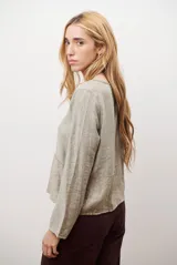 Chaqueta ligera de manga larga en color azul, con escote en V y cierre frontal mediante dos lazos ajustables. Presenta un diseño fluido con textura sutil y corte recto.