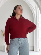 Sweater de punto color bordó con cierre de cremallera metálica en el cuello.