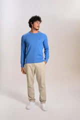 Sweater de punto de algodón en color azul, con cuello redondo, mangas largas con puños acanalados y logo de la marca bordado en el pecho.