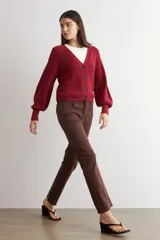 Cardigan de punto acanalado color bordó, con escote en V, cierre frontal de botones y mangas largas abullonadas con puños ajustados.