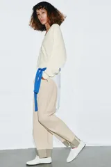 Jersey de punto color blanco crema, con escote en pico, manga larga y sisa ancha terminada en puño.