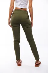 Pantalón chupín color verde militar, con bolsillos laterales y traseros, y cinturón marrón de cuero.