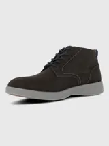 Bota urbana de caña baja confeccionada en cuero gamuzado color marrón oscuro, con cordones al tono y suela de poliuretano gris con tecnología de amortiguación.