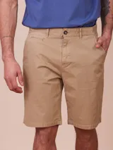 Bermuda color beige con bolsillos laterales y traseros. Cierre con botón y cremallera.